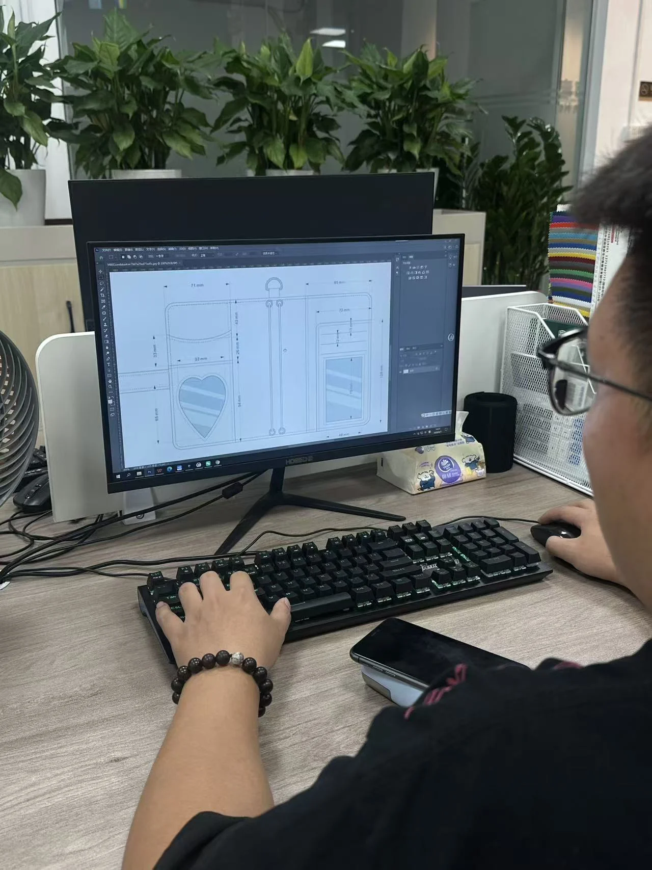 Hongzhao designer reviewing a custom bag technical drawing on a computer